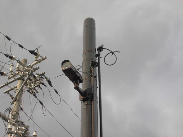 電信柱の上部に防犯カメラが設置されている写真