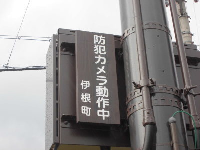 「防犯カメラ動作中 伊根町」と書かれた看板が電信柱に取り付けられている写真