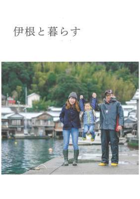 「伊根と暮らす」の文字と舟屋が写る海沿いで、夫婦が男の子を両手を握って持ち上げ笑顔で写る家族写真